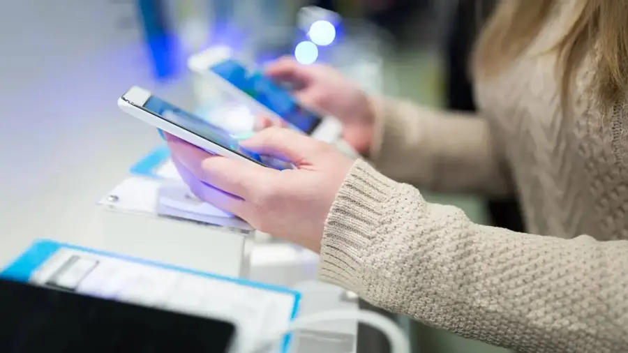 Pessoa comparando celulares antes da compra