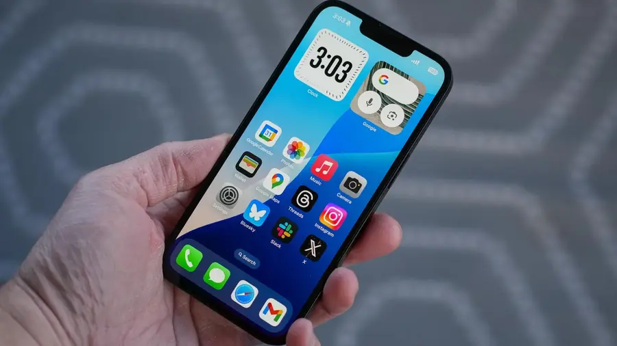iPhone 16e sendo segurado com uma mão, mostrando o design traseiro